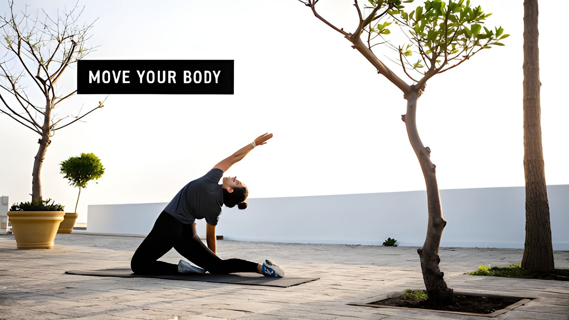 Person stretching on a mat outdoors by the sea, with