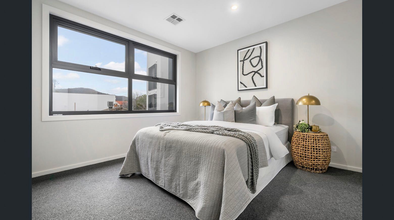 A bedroom with a large bed and a large window.