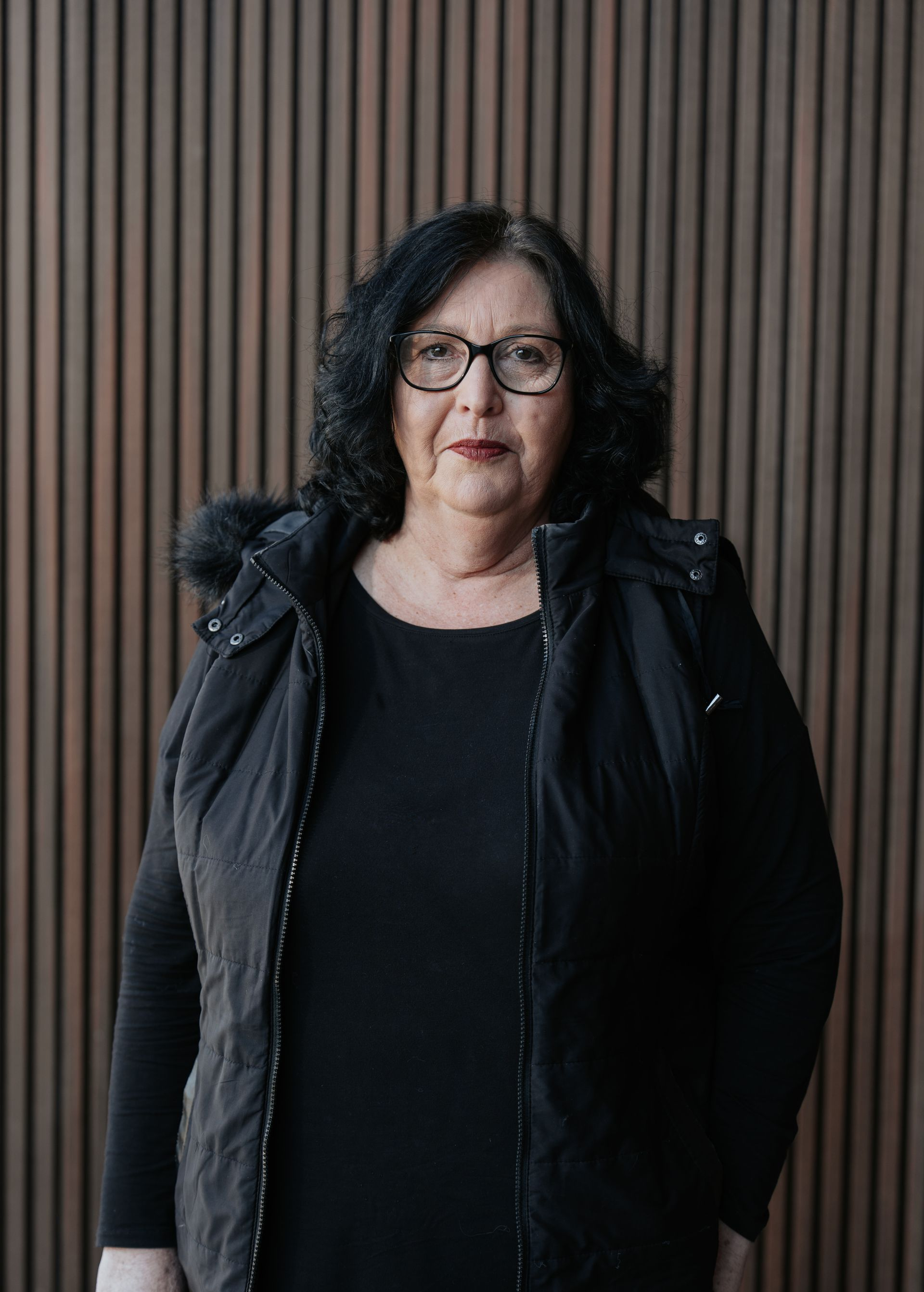 A woman wearing glasses and a black shirt is smiling for the camera.