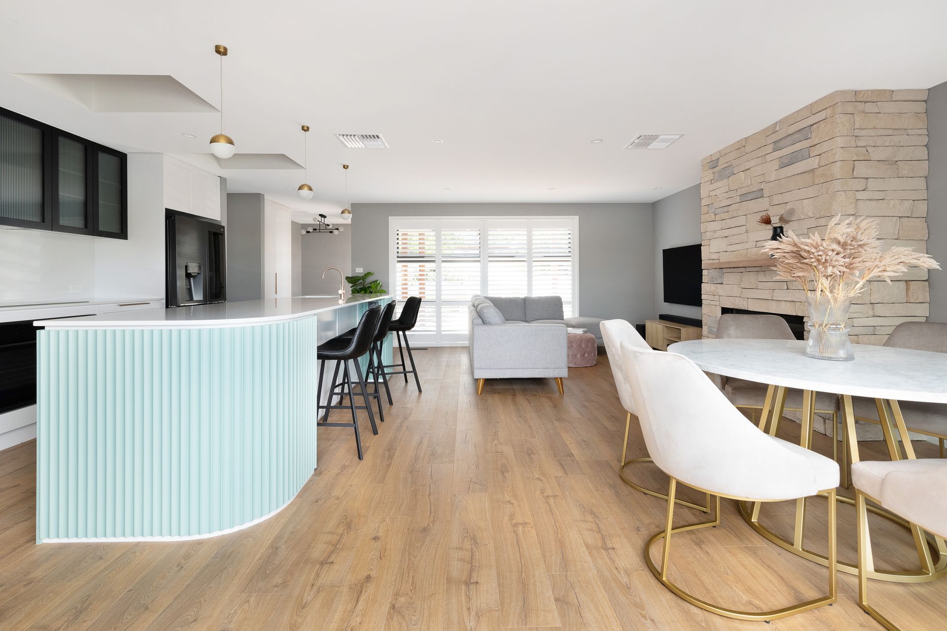 A living room with a dining table and chairs and a kitchen.