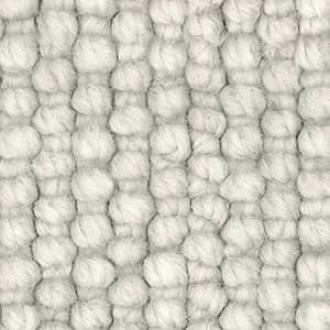 A close up of a white rug with a knitted pattern.