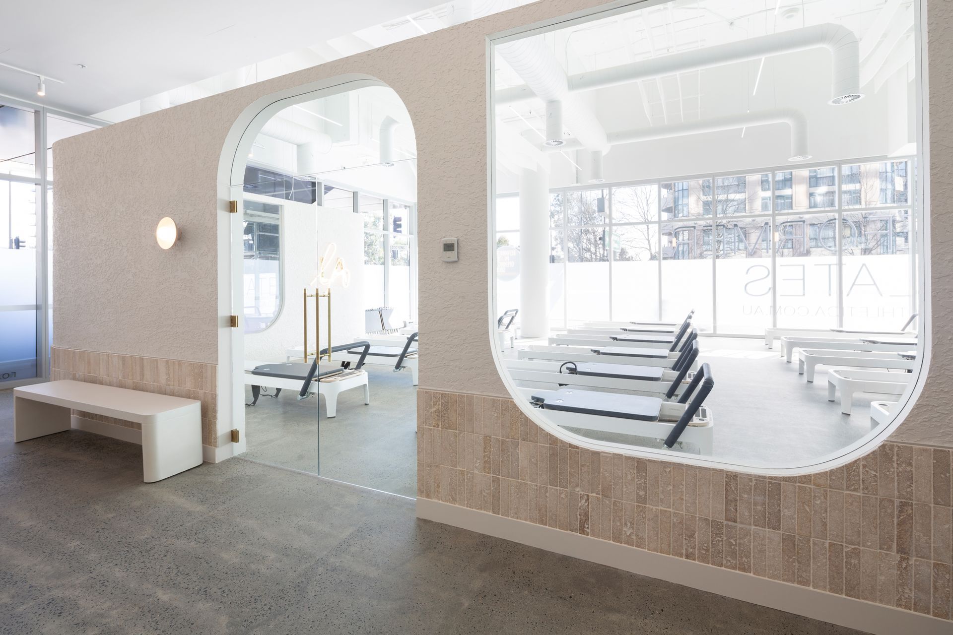 A gym with a glass door and a bench.