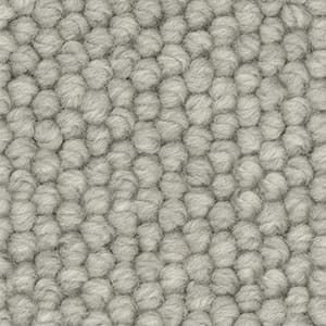 A close up of a white carpet with a knitted pattern.