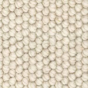 A close up of a white rug with a knitted pattern.