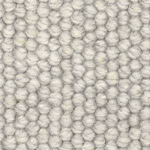 A close up of a white rug with a knitted pattern.
