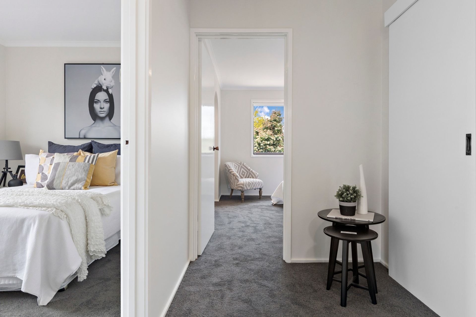 A bedroom with a bed and a hallway leading to it.