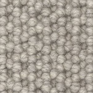 A close up of a white carpet with a knitted pattern.