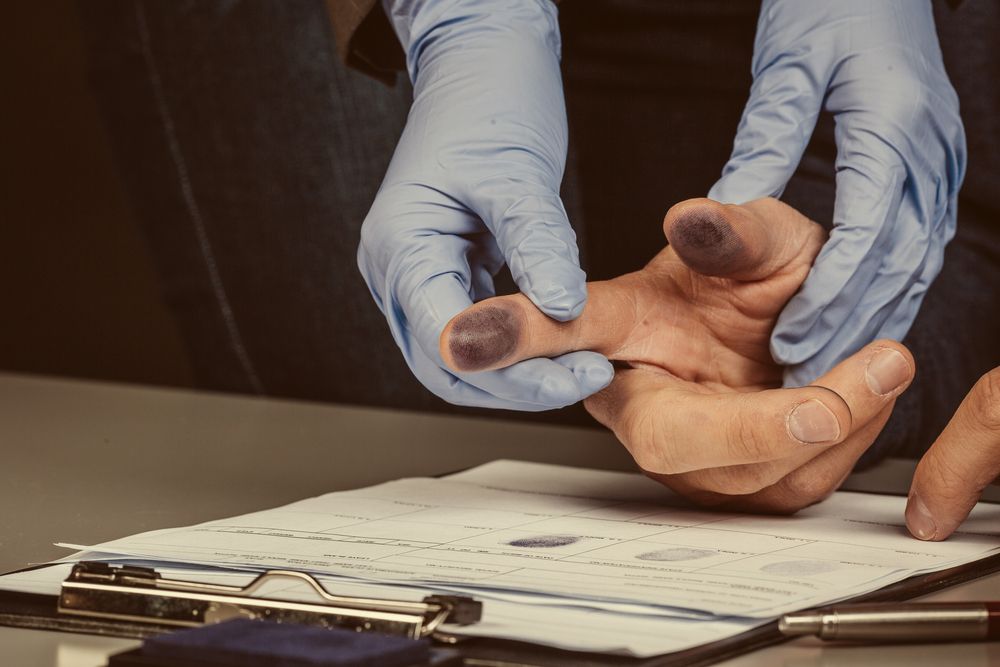 A person wearing blue gloves is examining a person's hand