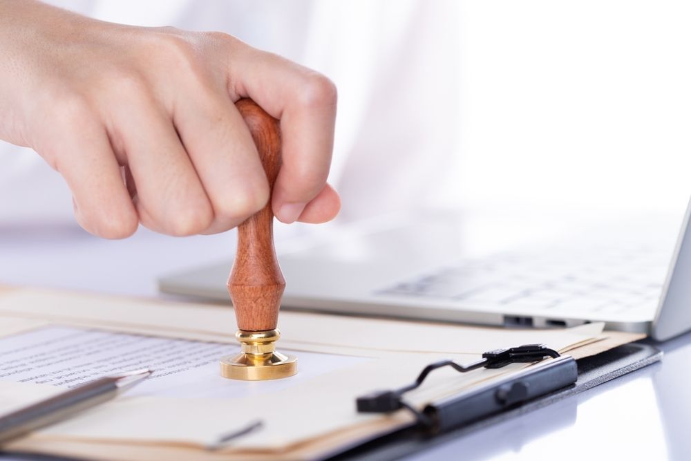A person is stamping a document on a clipboard