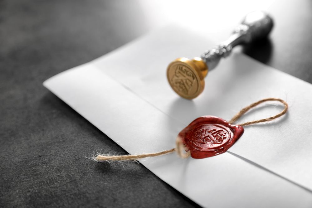 A wax seal is sitting on top of an envelope