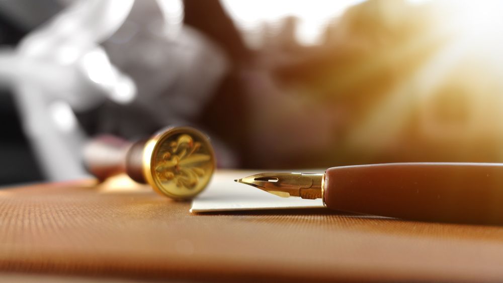 A fountain pen is sitting on top of a piece of paper on a table