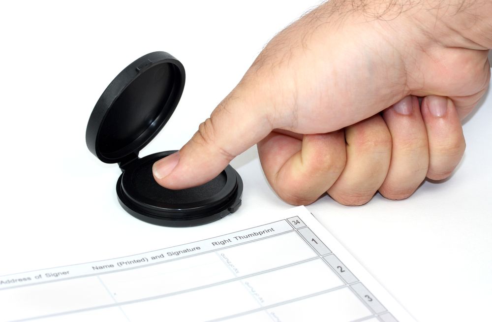 A person is stamping a document with their finger