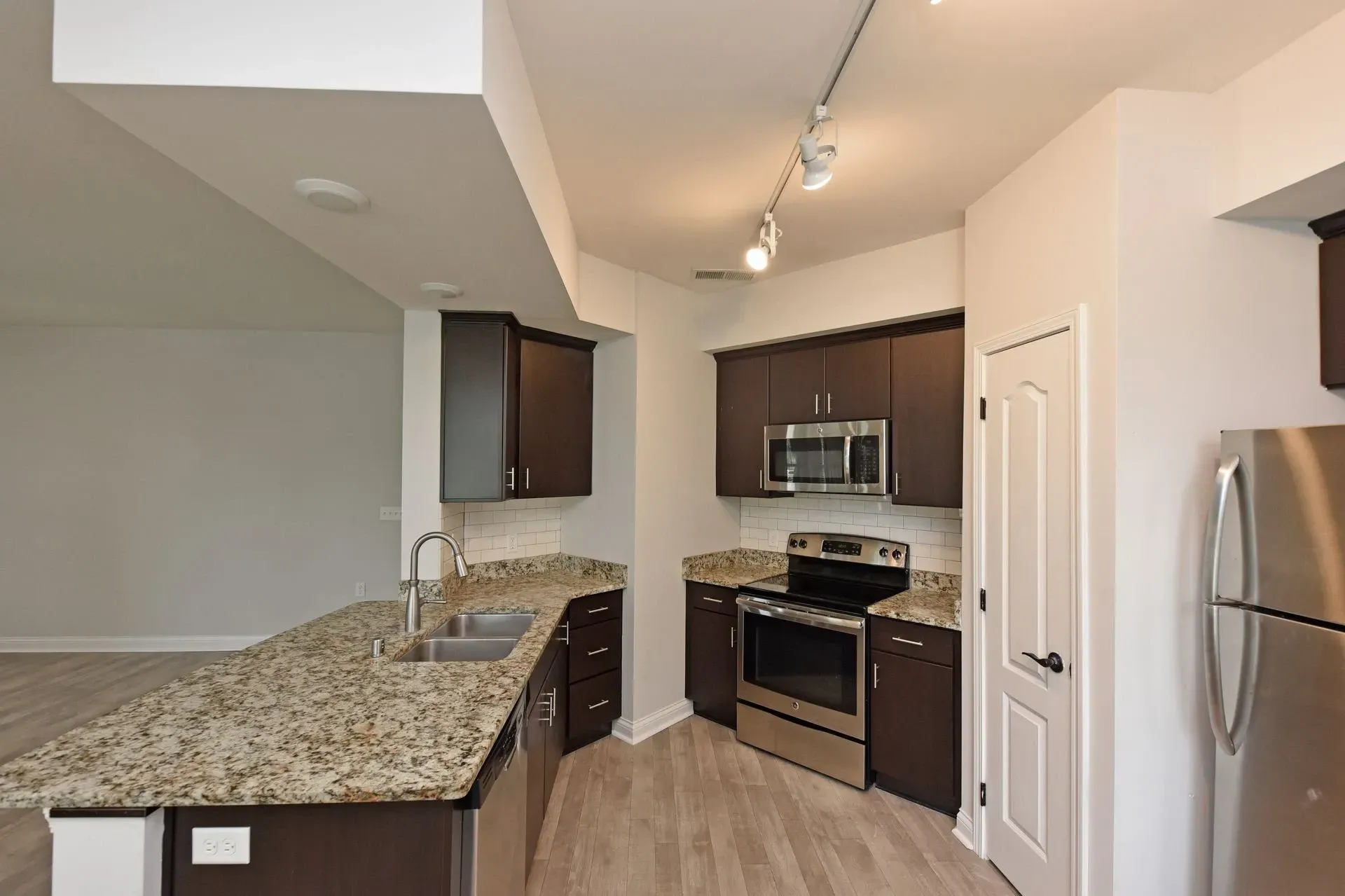 Modern kitchen with granite countertops and stainless steel appliances.