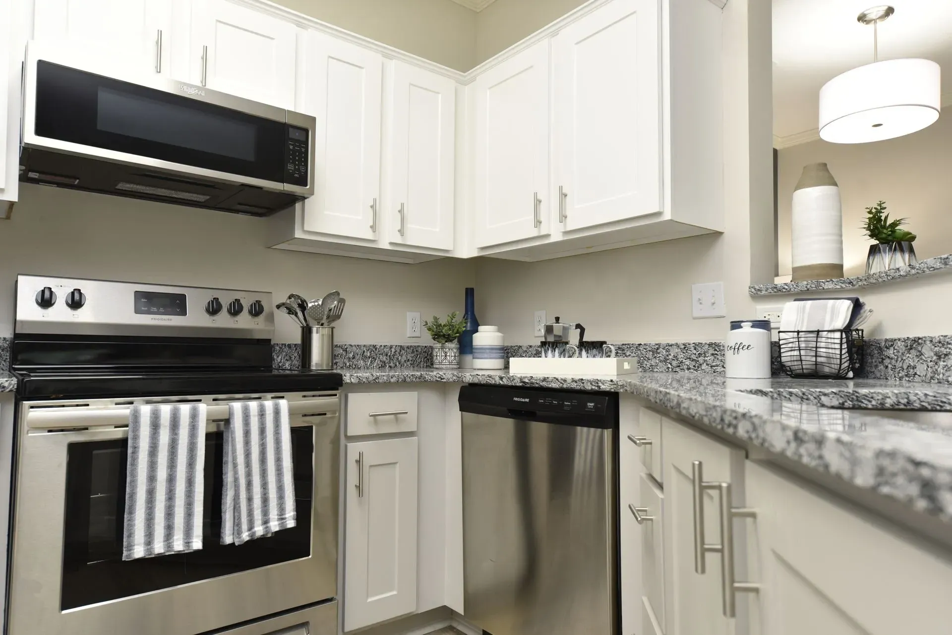 Modern kitchen with stainless steel appliances and white cabinetry.