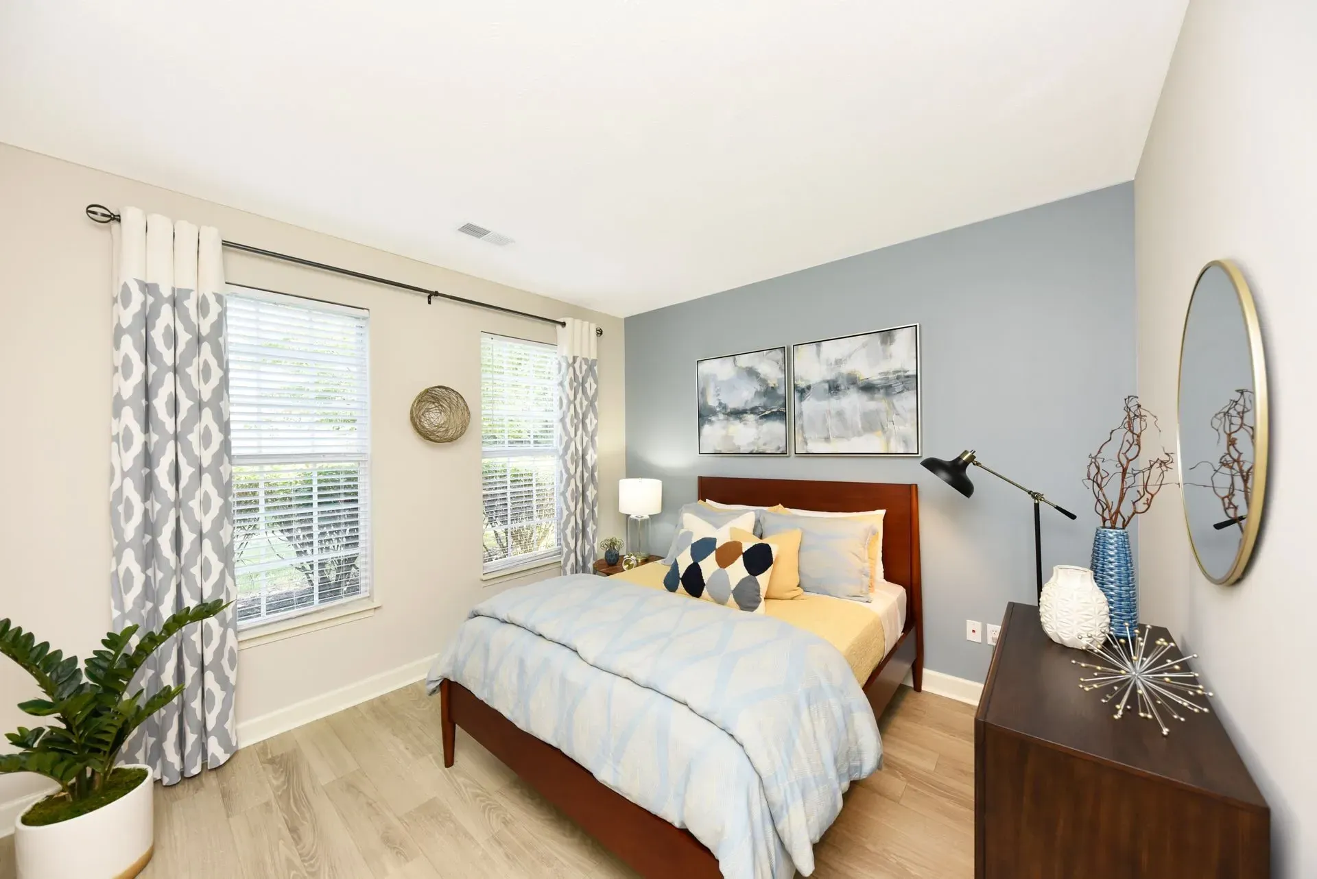 A cozy bedroom with a queen-size bed, neutral bedding, and decorative pillows.