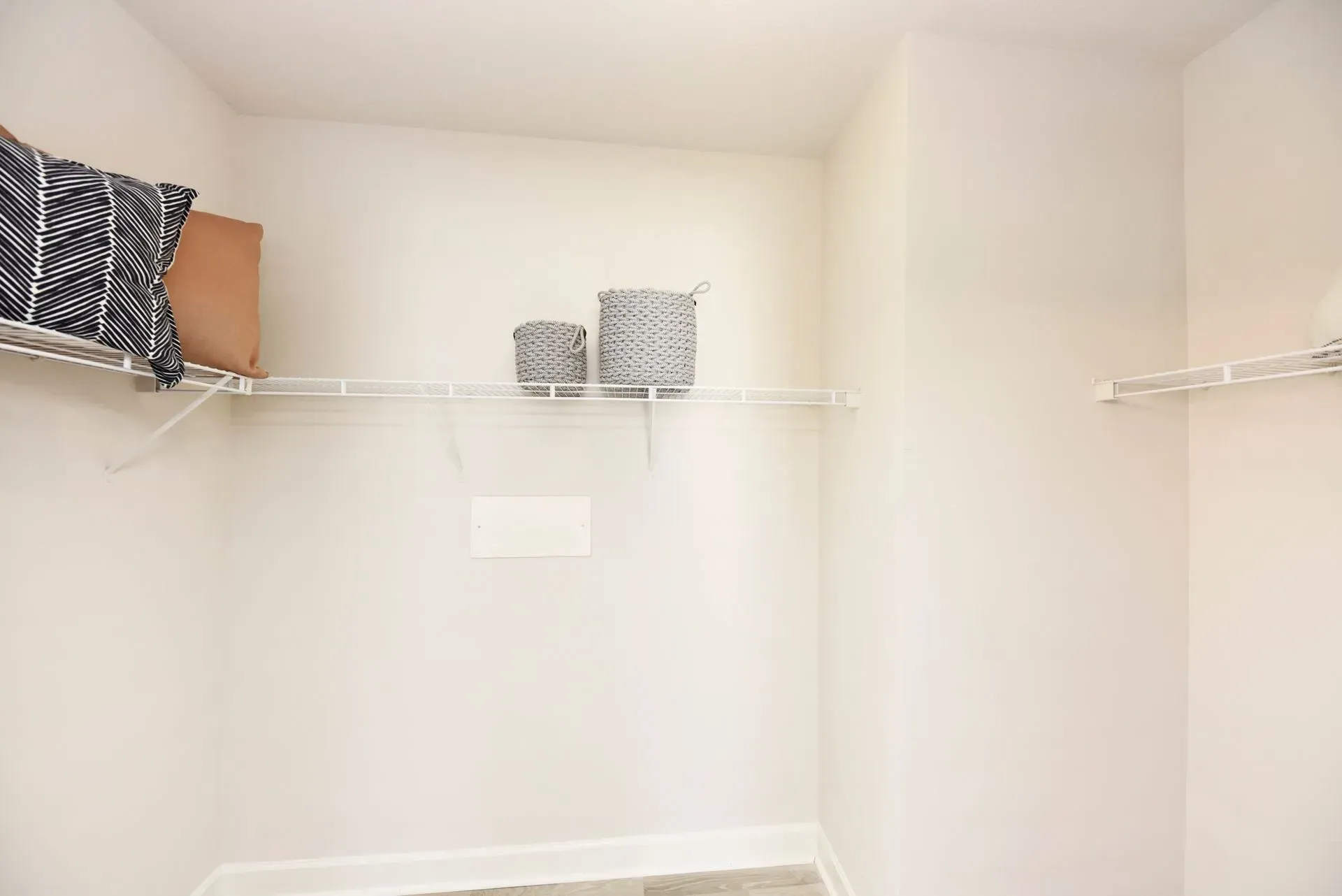 Empty closet with shelves and decorative baskets.
