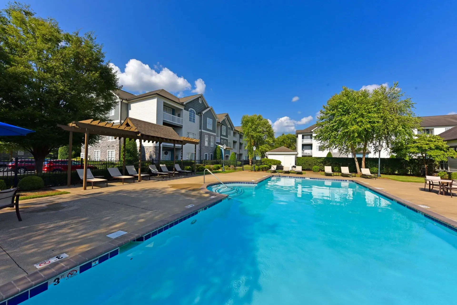 Swimming pool and lounge chairs at apartment complex.