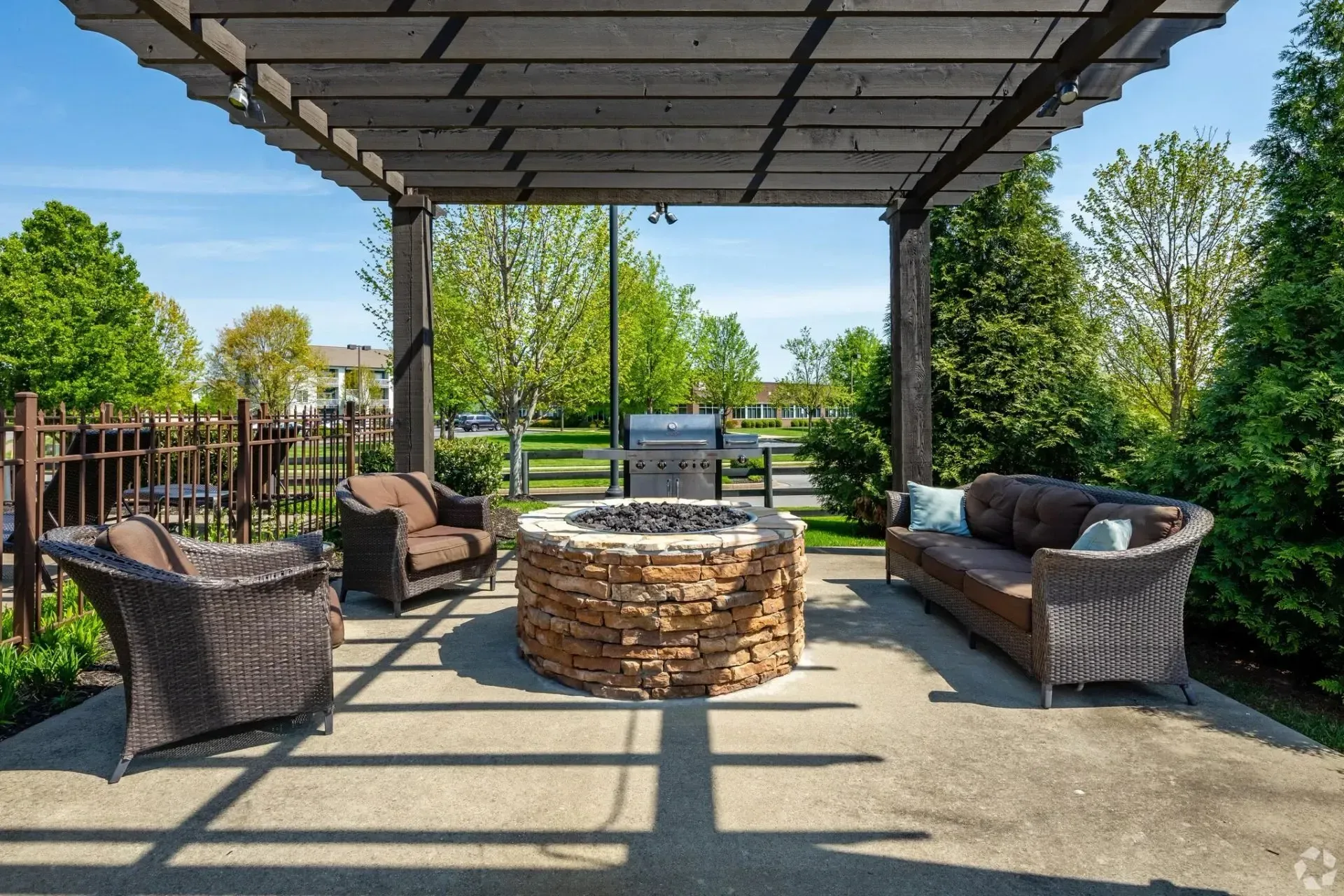 Outdoor seating area with a fire pit and grill.