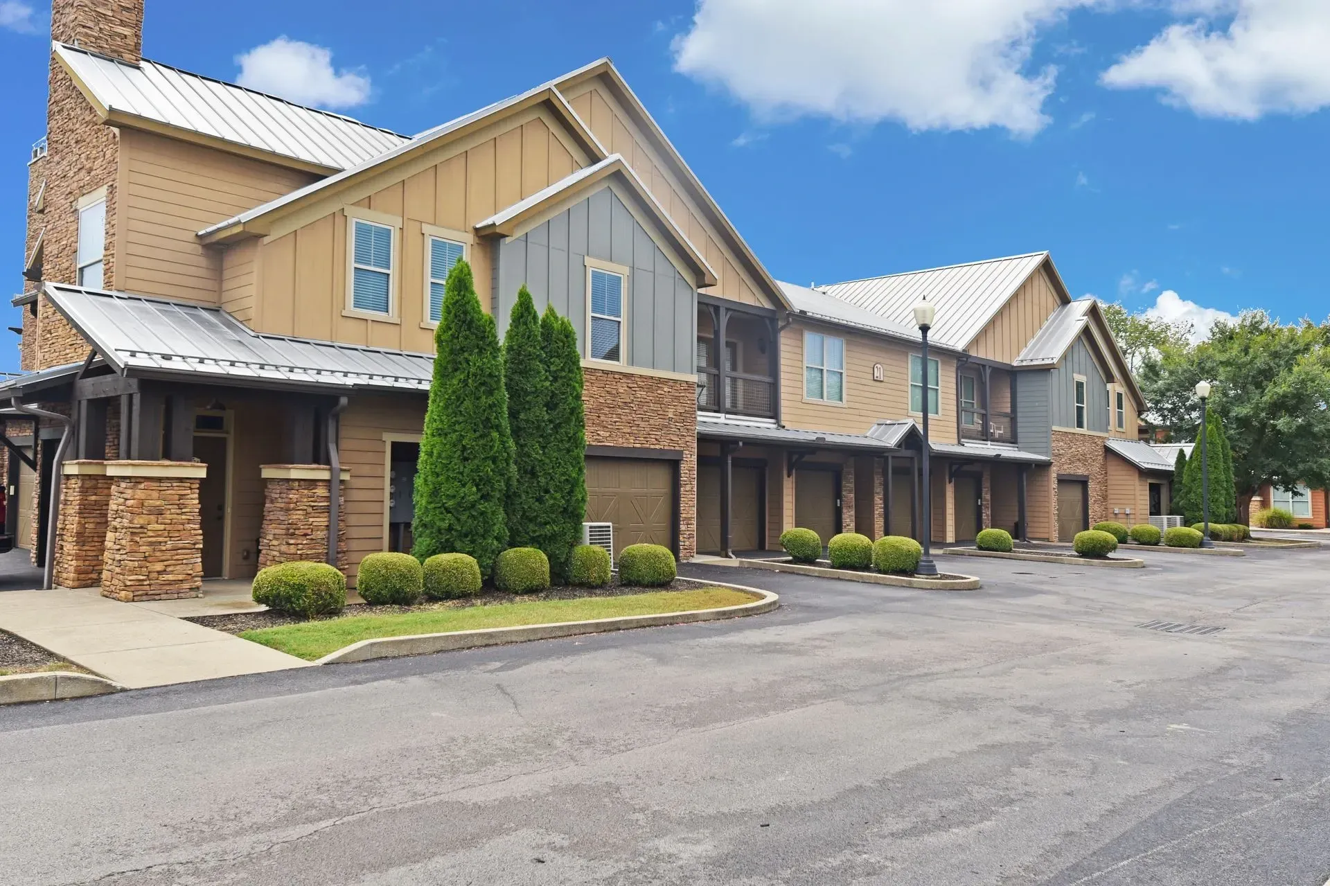 Exterior of apartment buildings with garages and manicured landscaping.