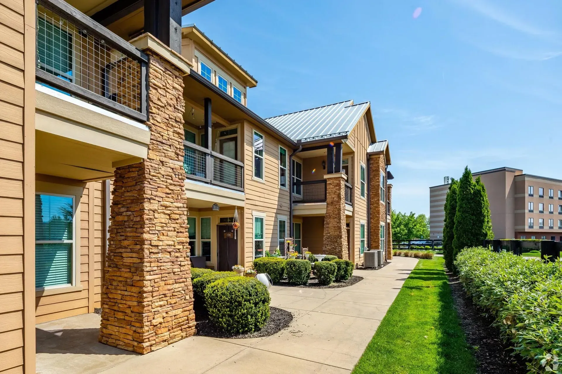 Exterior of apartment building with stone accents and balconies.