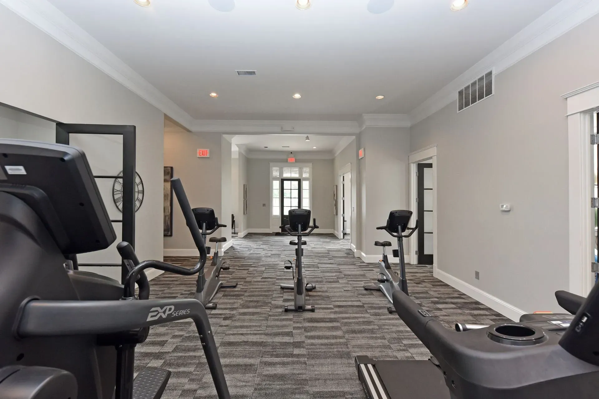 Interior of a modern apartment complex fitness center with cardio machines.
