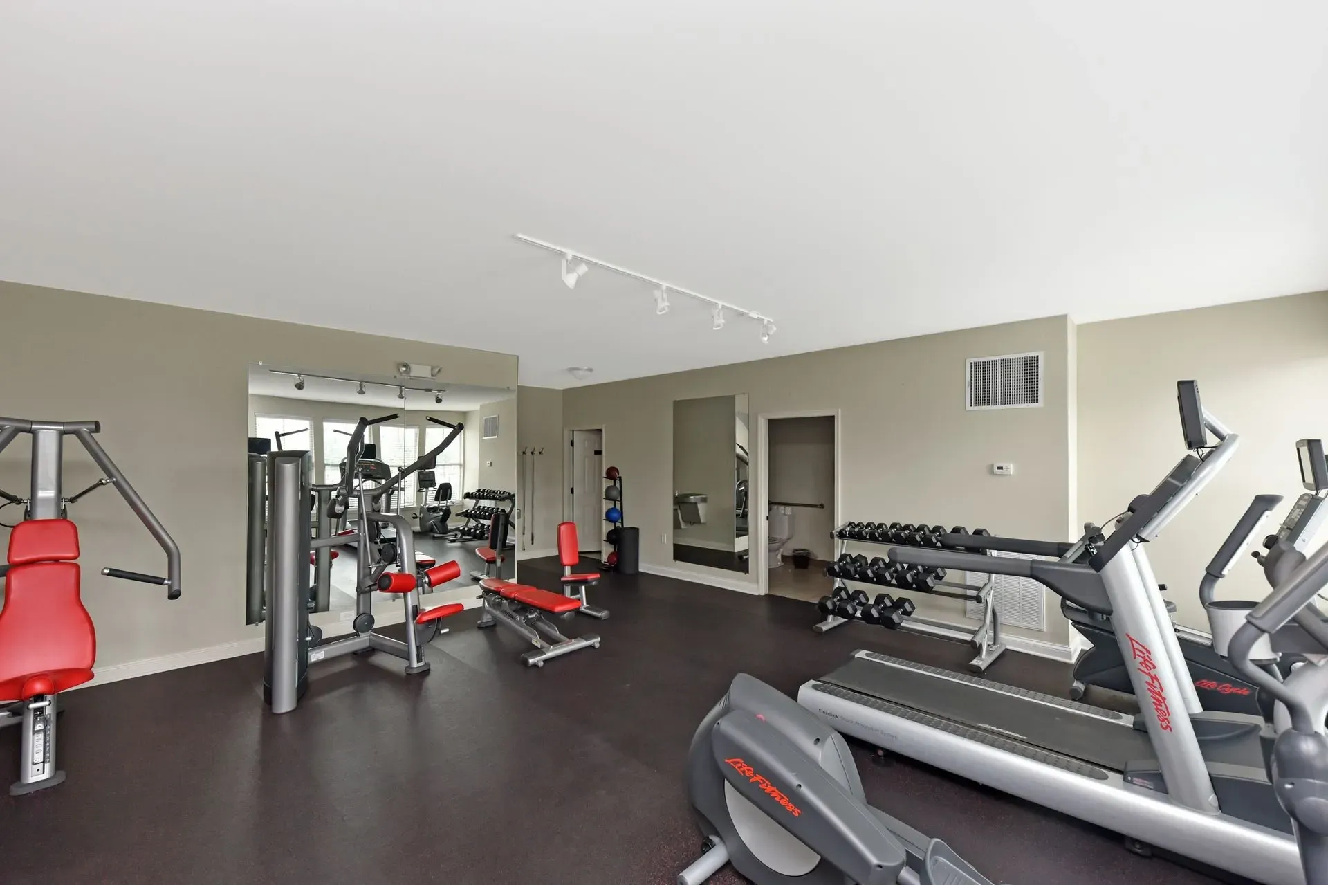 Gym with treadmills, ellipticals, weight machines, and free weights.