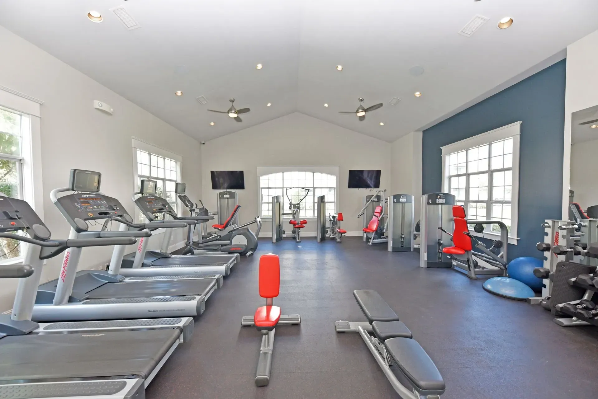 Spacious fitness center with treadmills, elliptical machines, and weight training equipment.