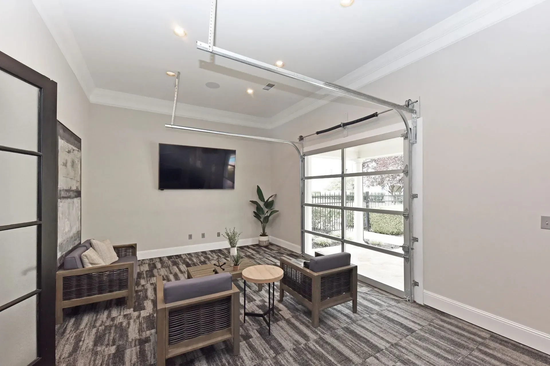 Modern lounge area with chairs, coffee table, and large television.