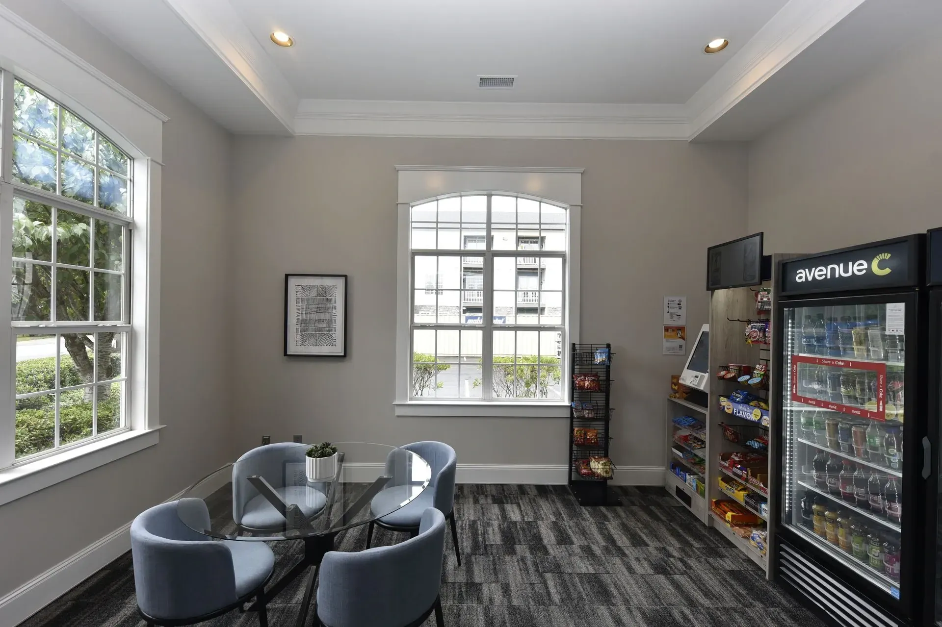 Community lounge area with seating, vending machines, and a table with chairs.