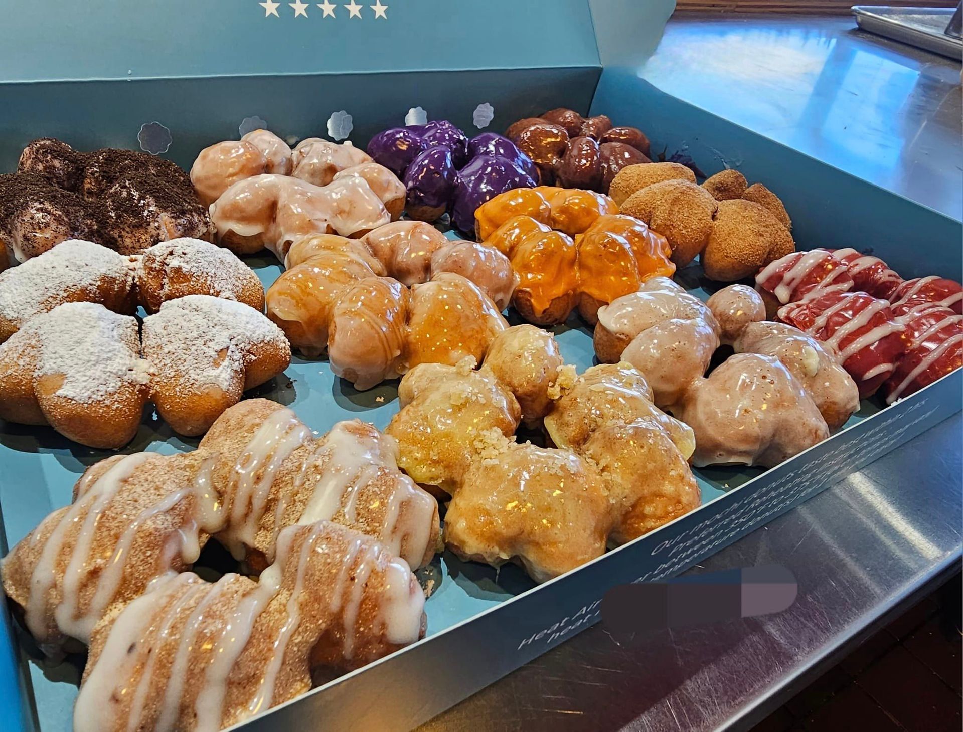 Assorted glazed donuts and pastries in a display tray on a bakery counter