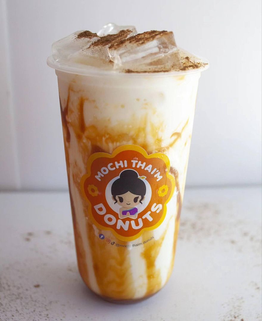 Iced caramel mocha drink in a clear cup with a Mochi Thai Donuts logo