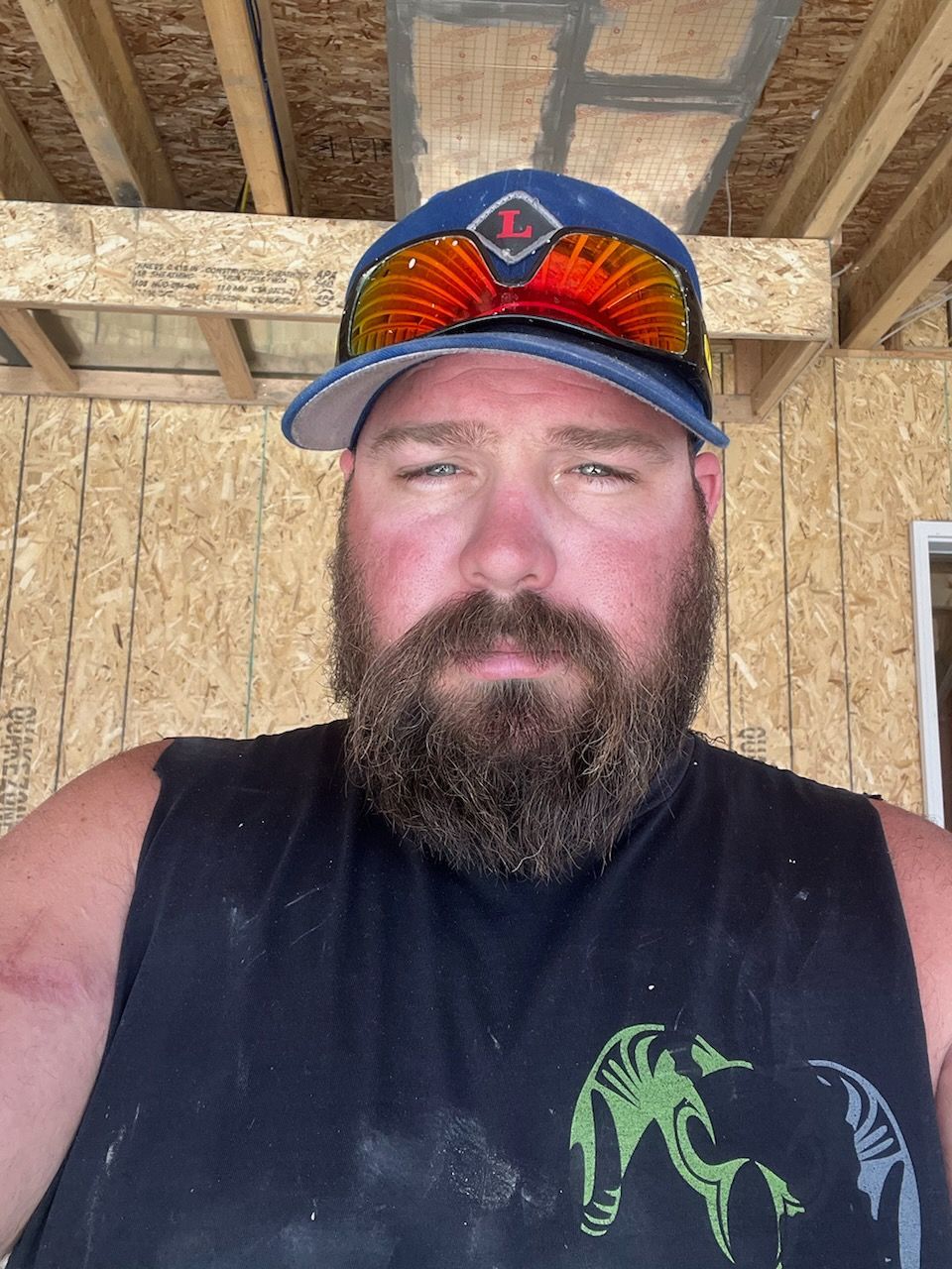 Cody with a beard is wearing a hat and sunglasses.
