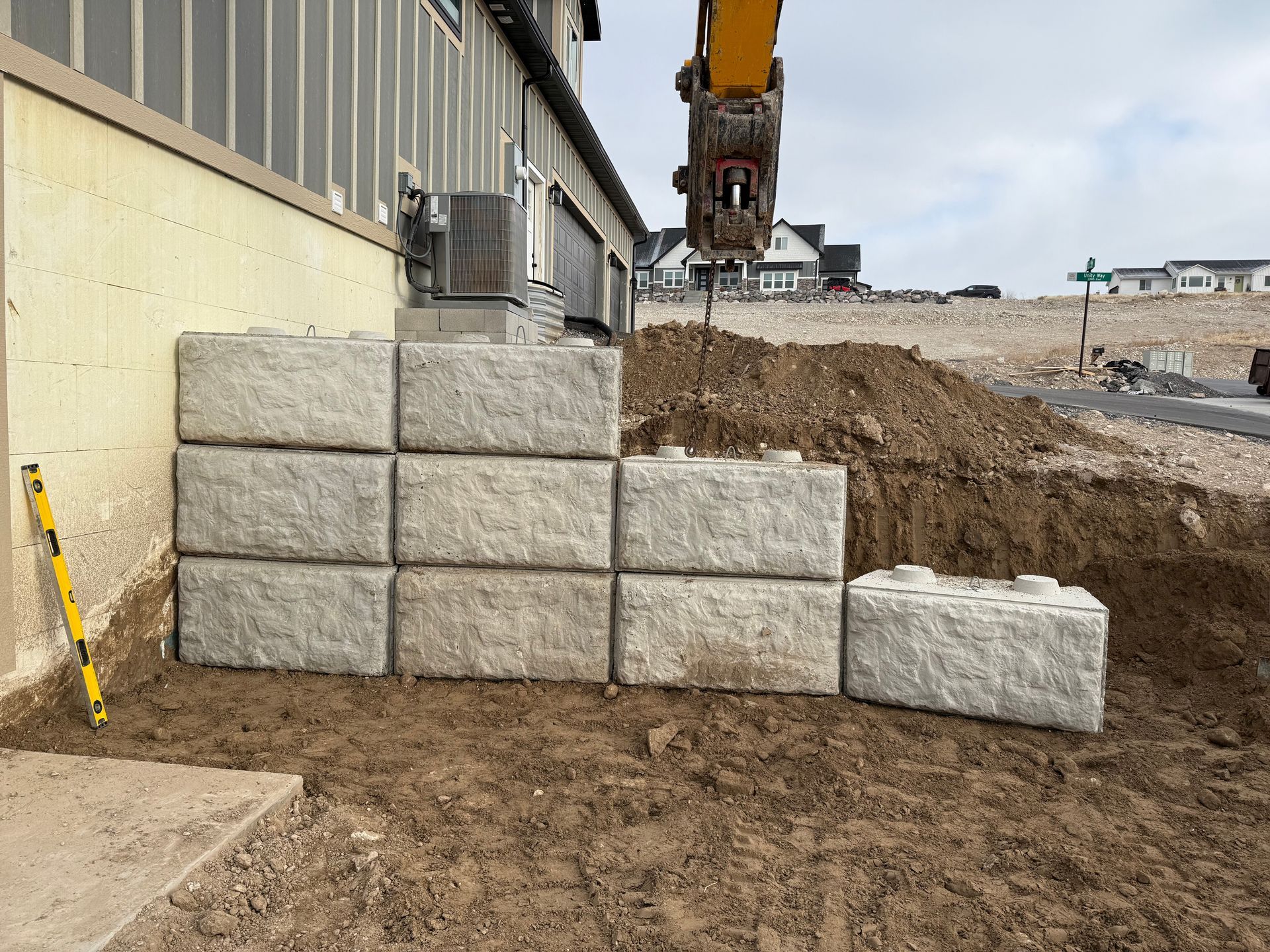 A stack of concrete blocks are being lifted by a crane.