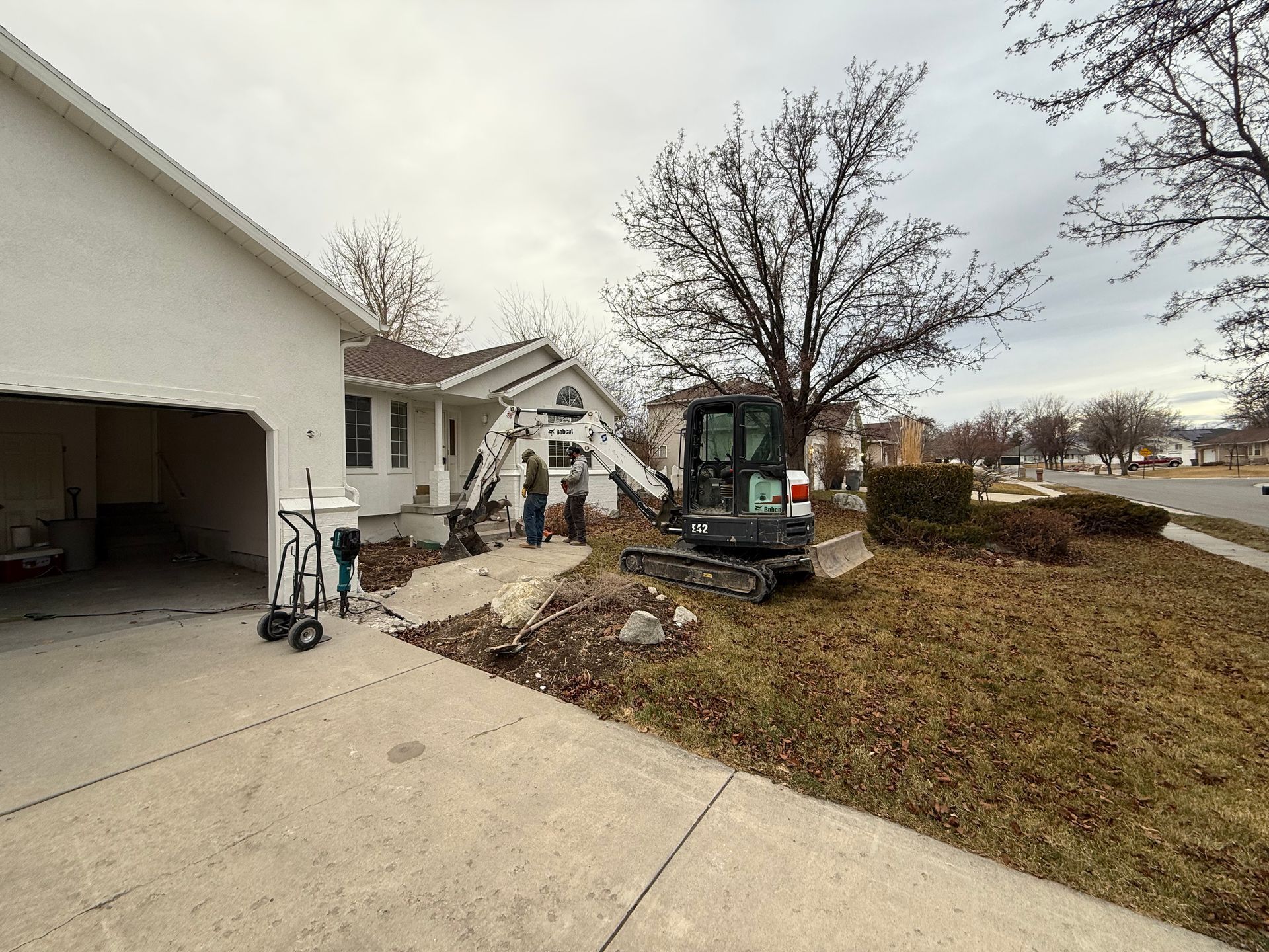 A concrete excavator is parked in front of a house.