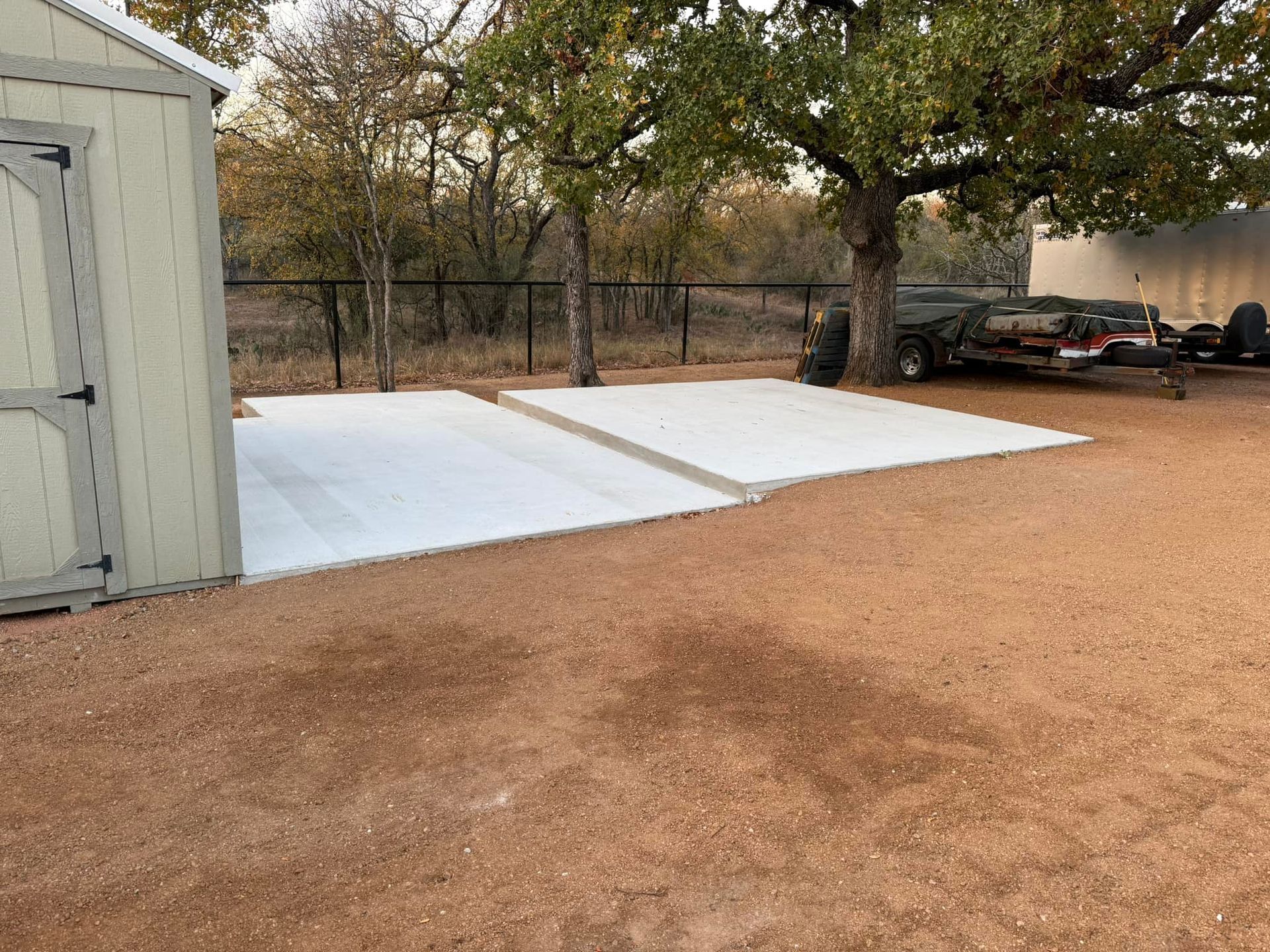 A car is parked in a driveway next to a shed.