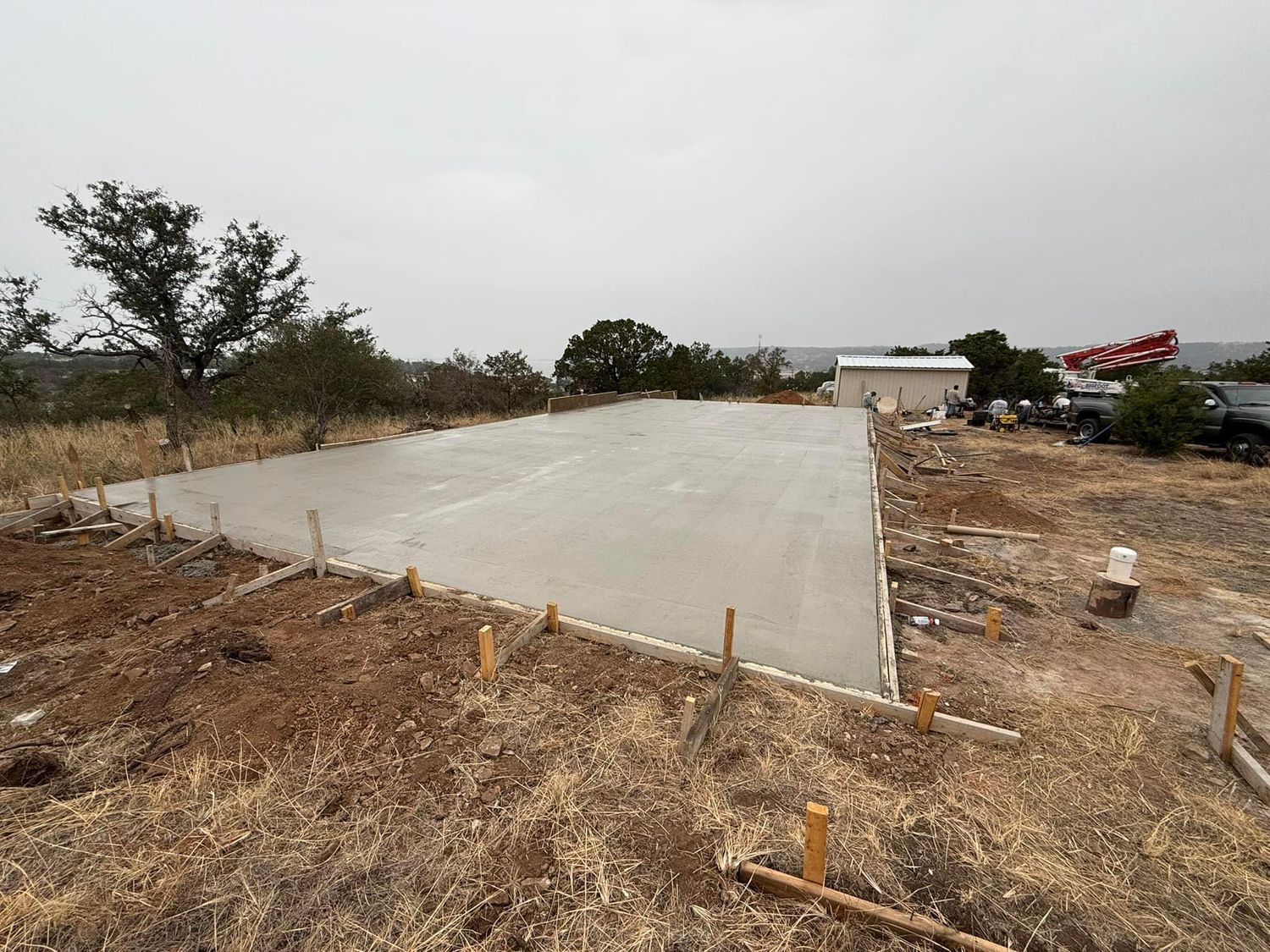 A large concrete slab is sitting in the middle of a dirt field.