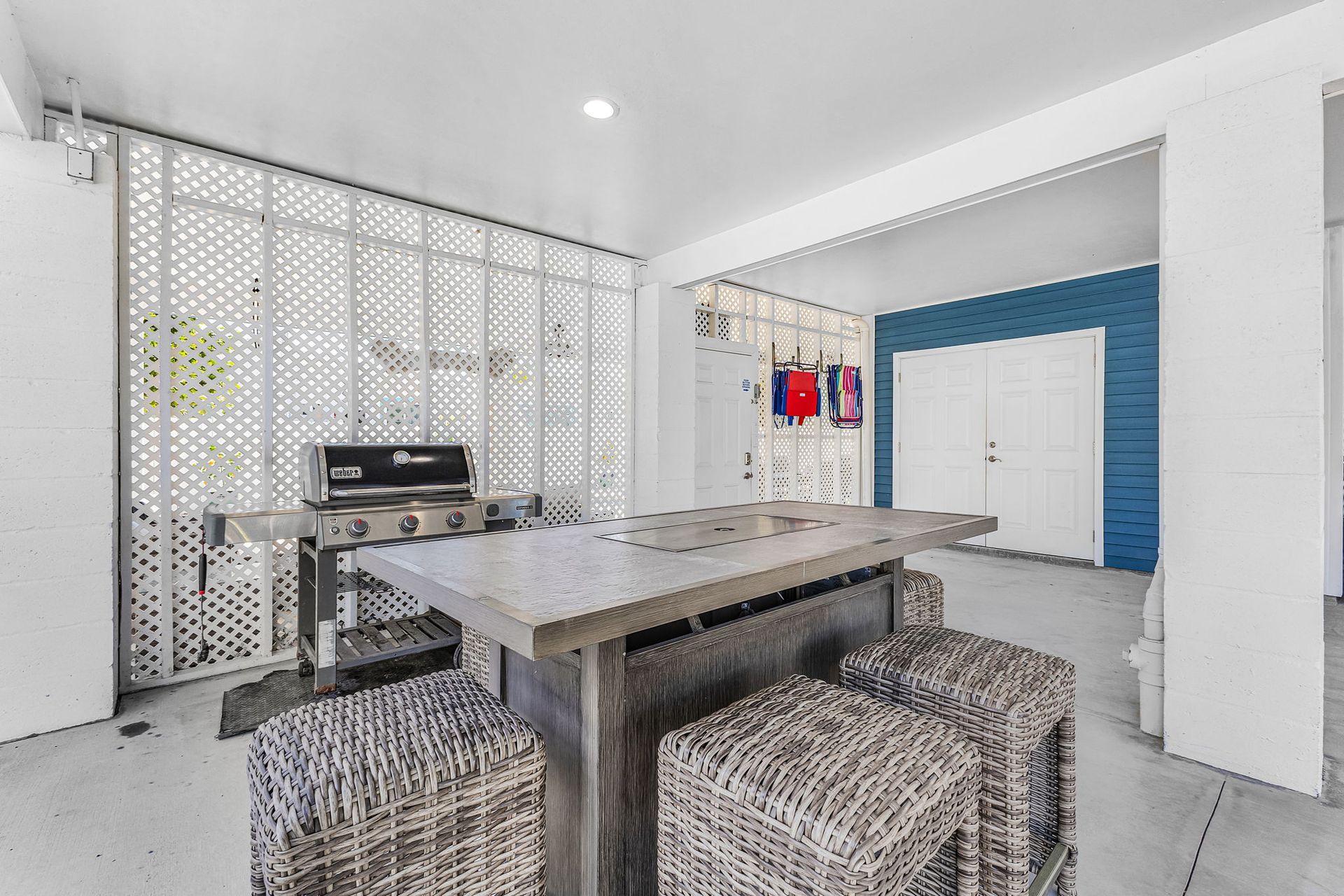 Bright dining area with a wooden table, patterned stools, blue accent wall, and decorative curtains