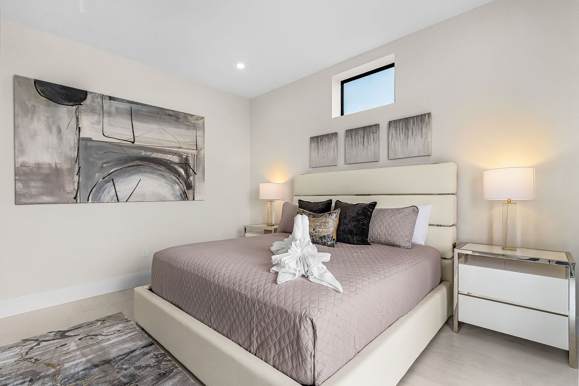 Bedroom with bed, nightstands, artwork, and window.