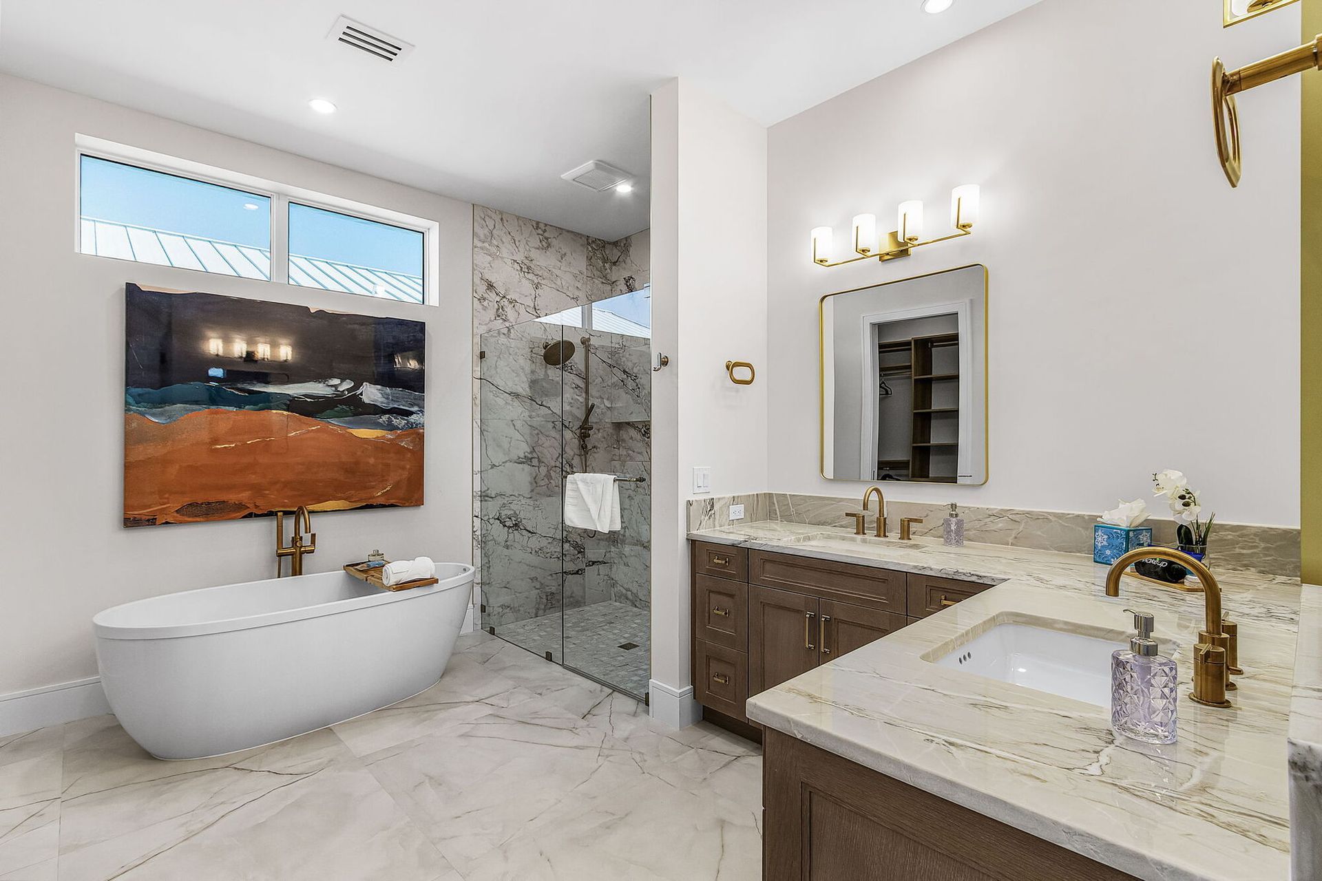 Modern bathroom with freestanding tub, glass shower, double vanity, and white tile finishes