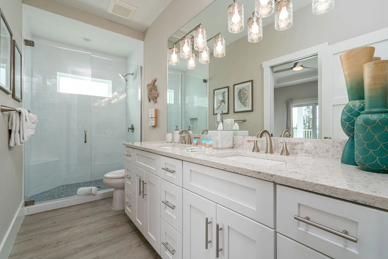 Bright modern bathroom with double vanity, large mirror, and glass shower door