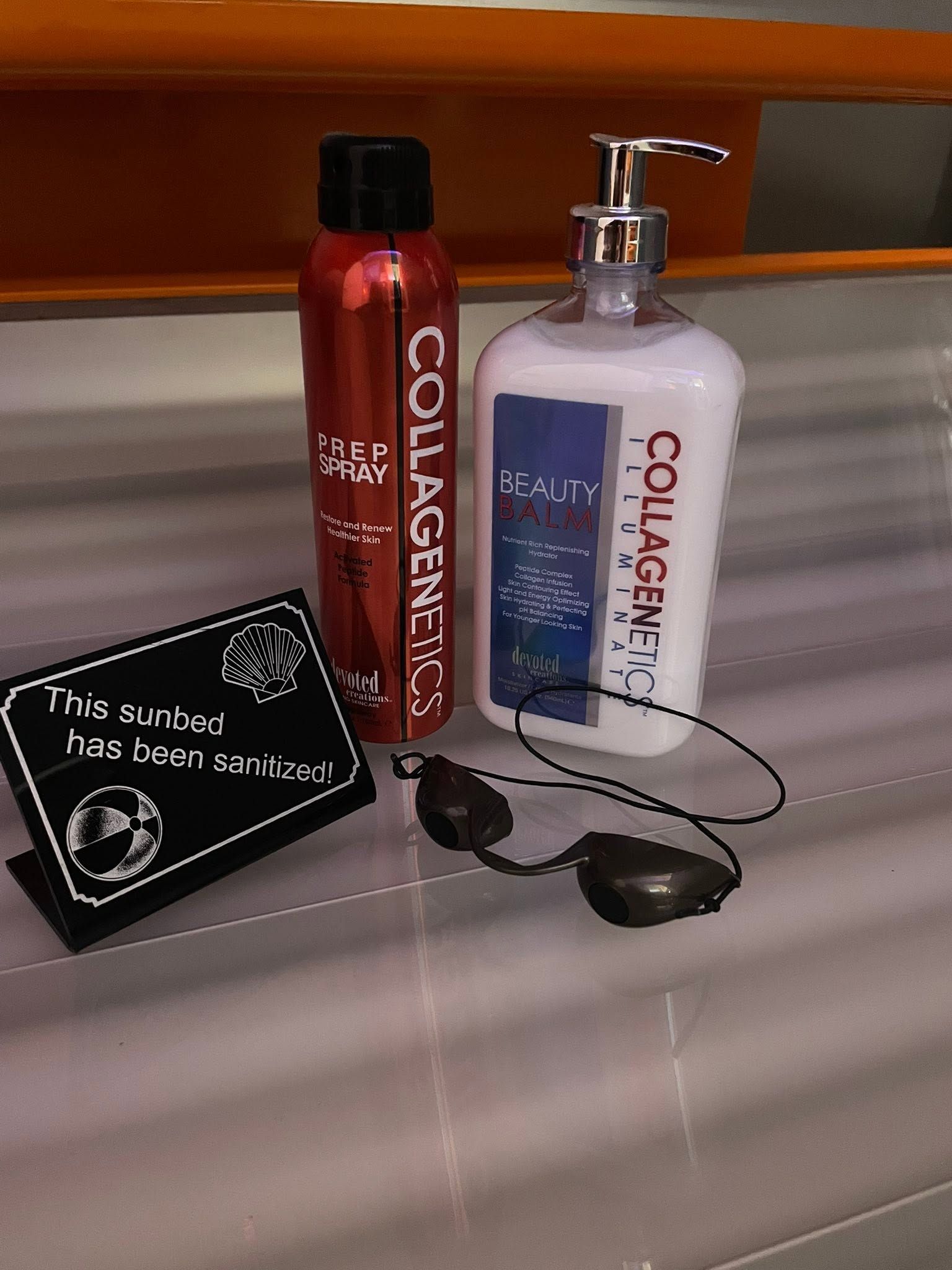 Sunglasses beside two Collagen shampoo bottles and a small black sign on a counter.
