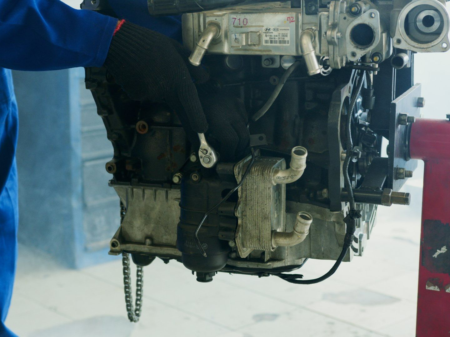 A man is working on a car engine in a garage.