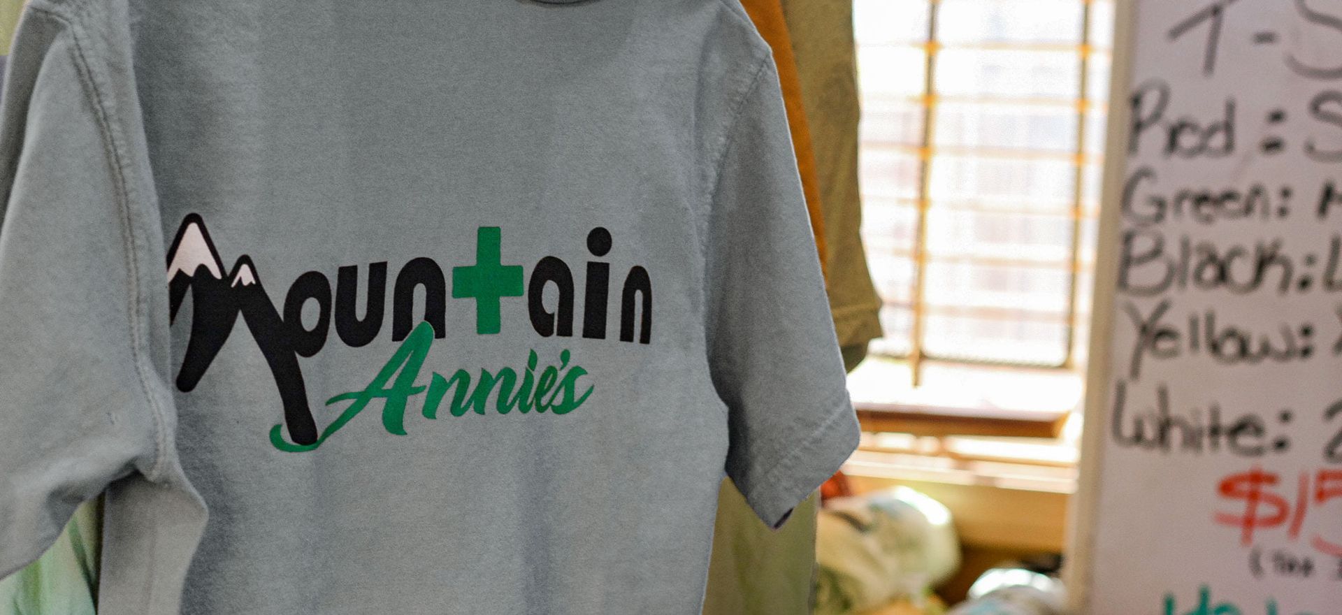 A grey t-shirt featuring the black and green logo 