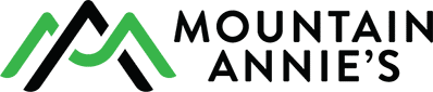 Logo for Mountain Annie's featuring a stylized mountain icon in black and green next to the brand name in black text.