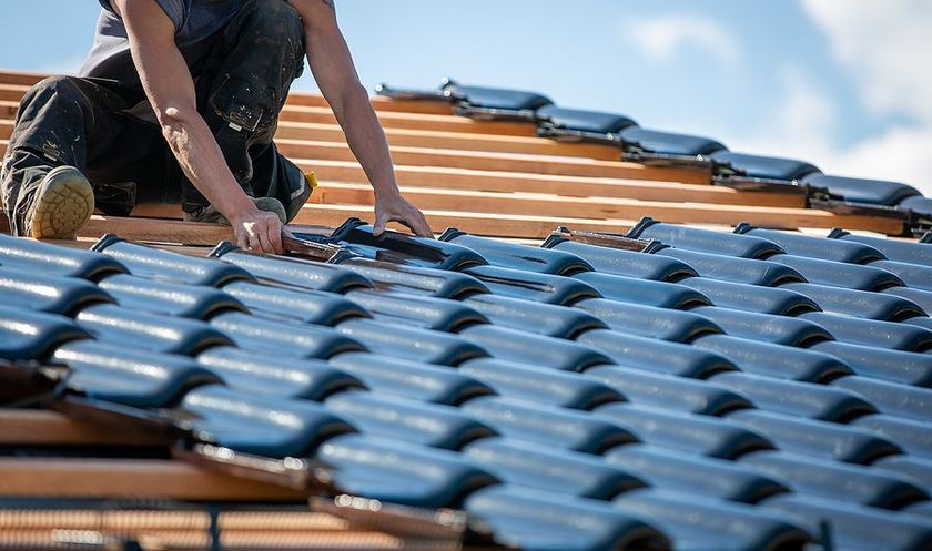 a man working on a roof of a building
