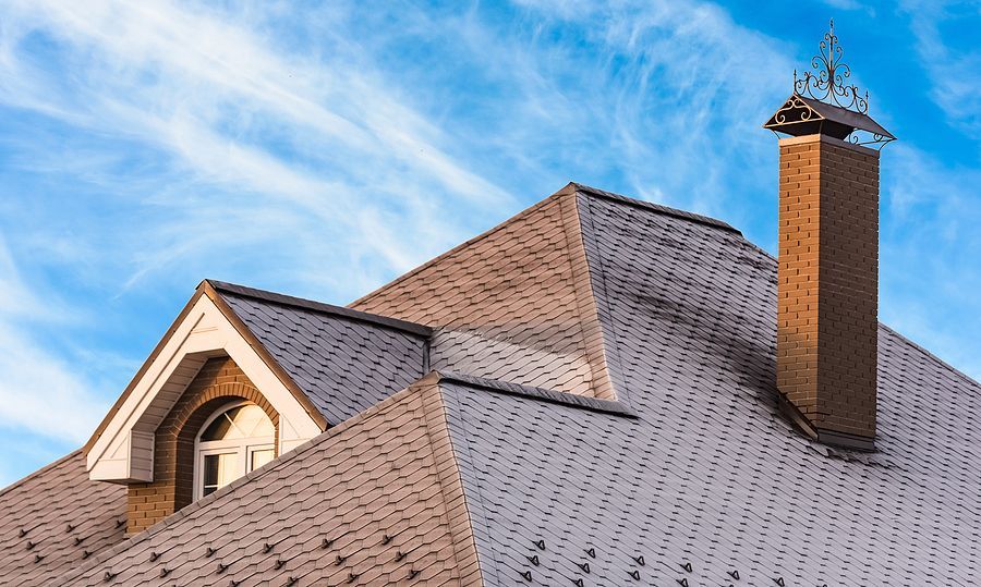 a roof with a chimney and a weather vane on top