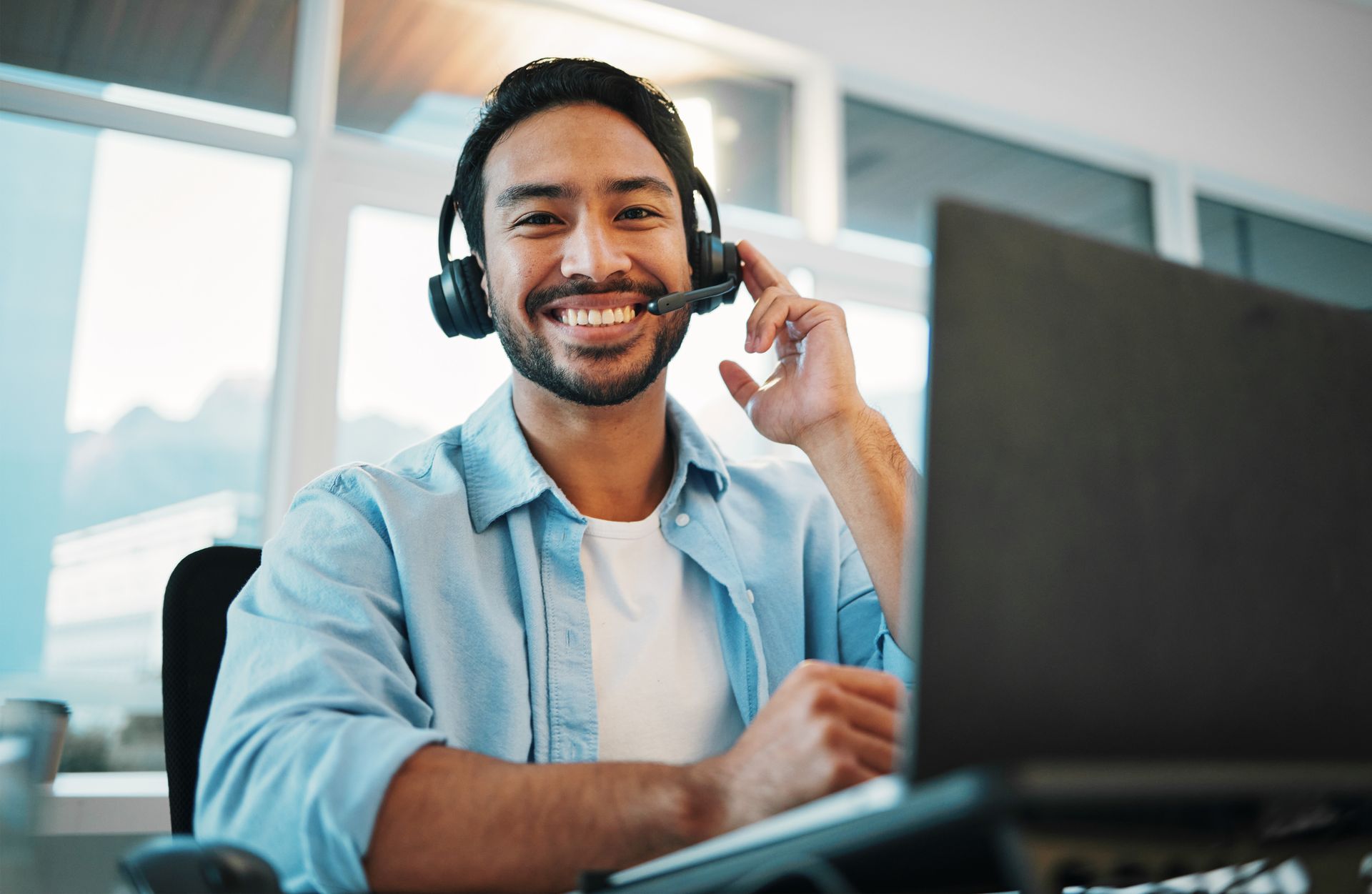 IT support specialist assisting a customer via computer and headset.