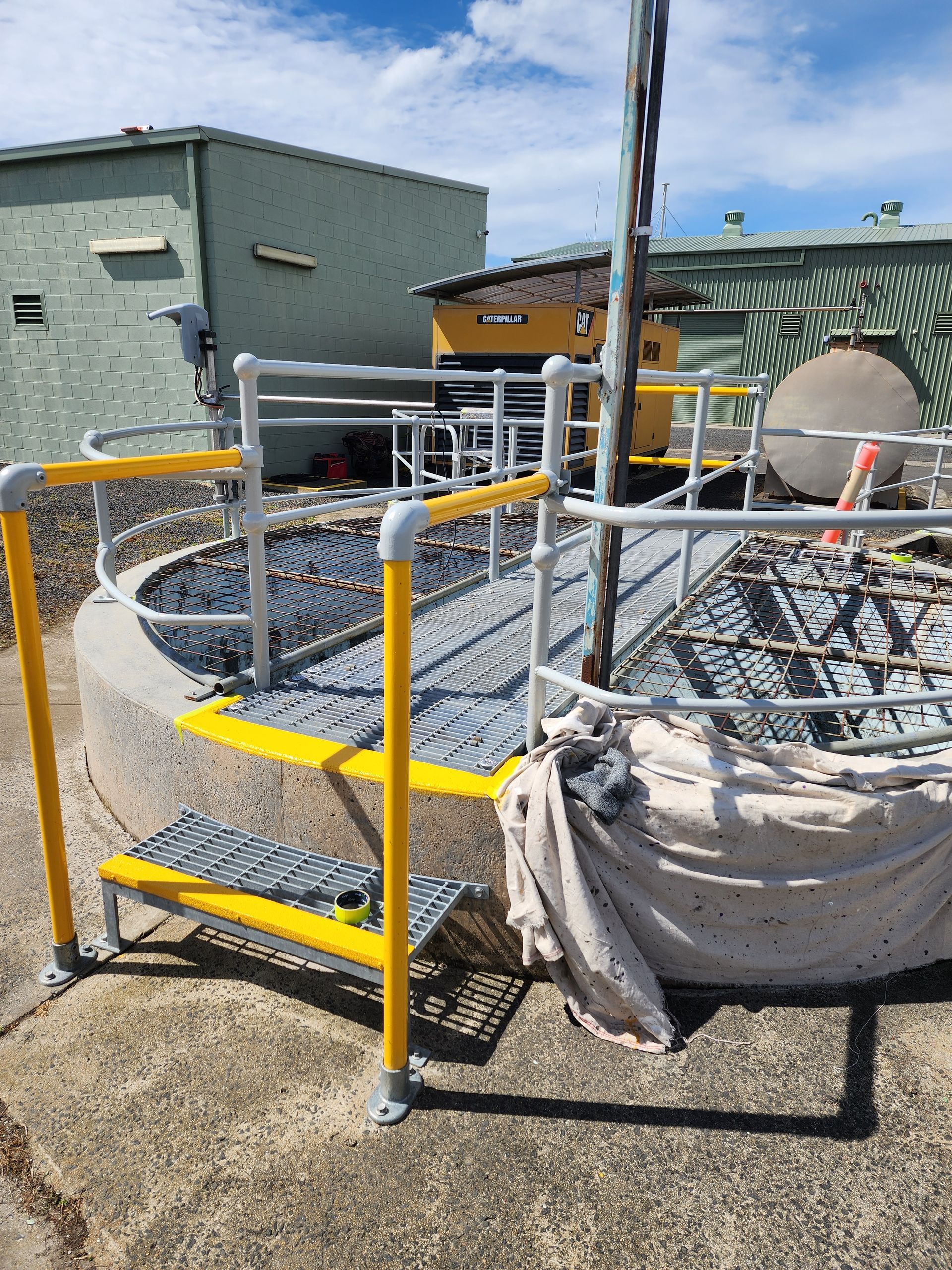 A metal platform with stairs and a fence around it is sitting on the ground.