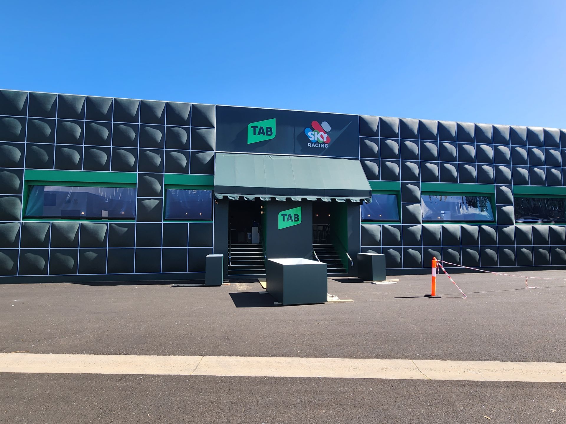 A black building with a green awning and the word the on it