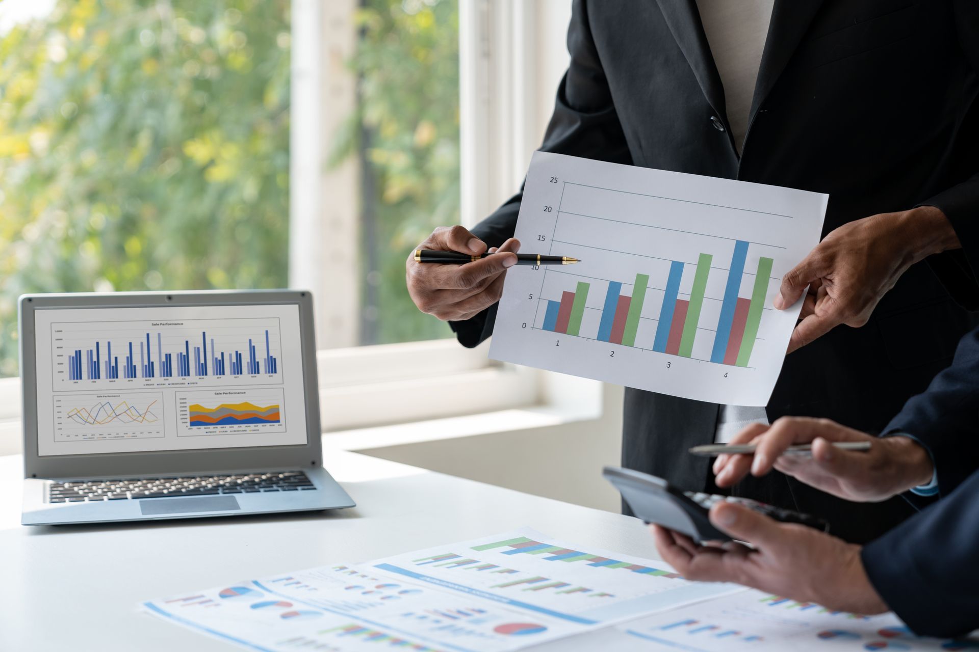 A group of business people are looking at a graph on a piece of paper.